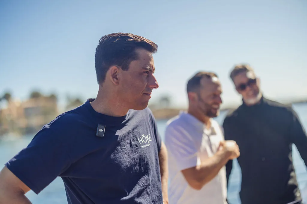 Yacht broker Julian Hoeke in conversation with a buyer on the dock at Puerto Portals, Mallorca — the personal consultation that anchors every yacht purchase