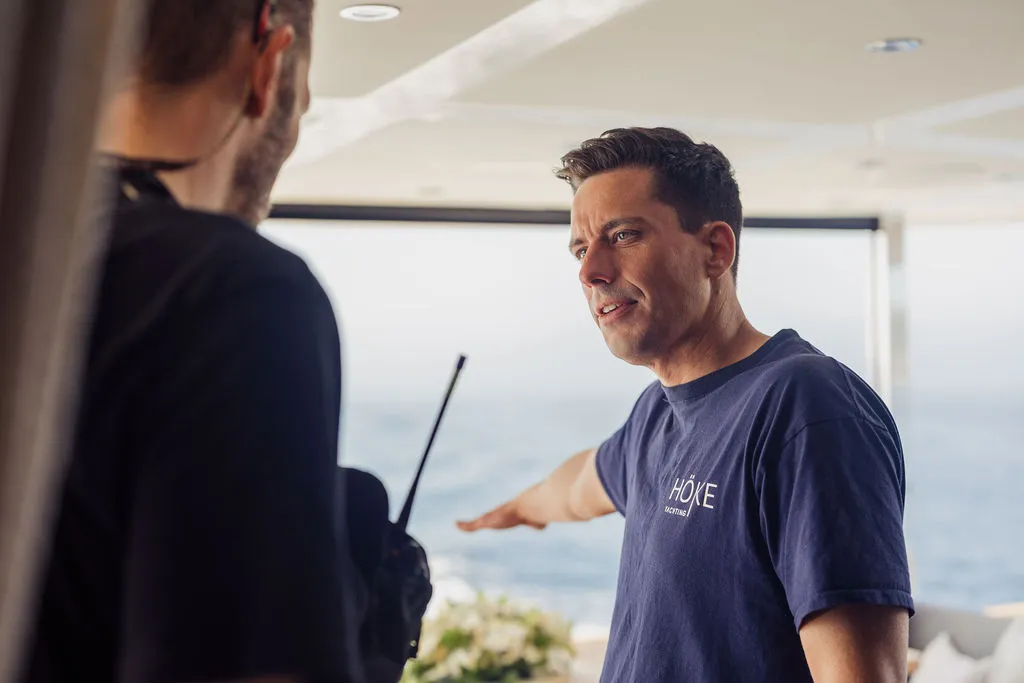 Yachtmakler Julian Hoeke in HÖKE-Polohemd bei der Arbeit an Bord einer Yacht in Puerto Portals, Mallorca