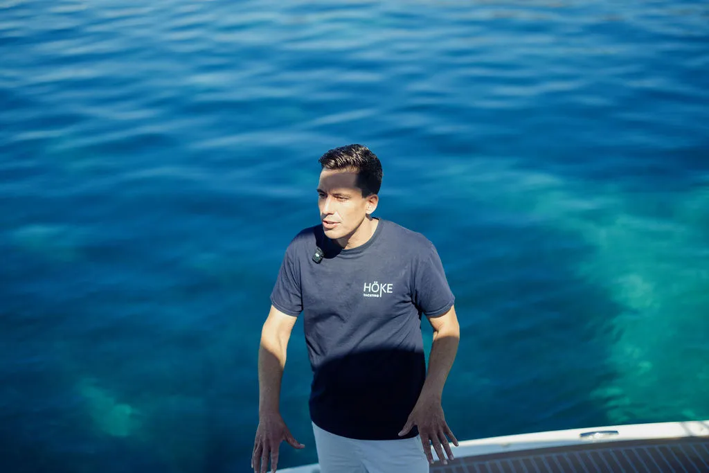 Yachtmakler Julian Hoeke auf einer Yacht vor Mallorca — Portrait im HÖKE-Polo vor tiefblauem Meer