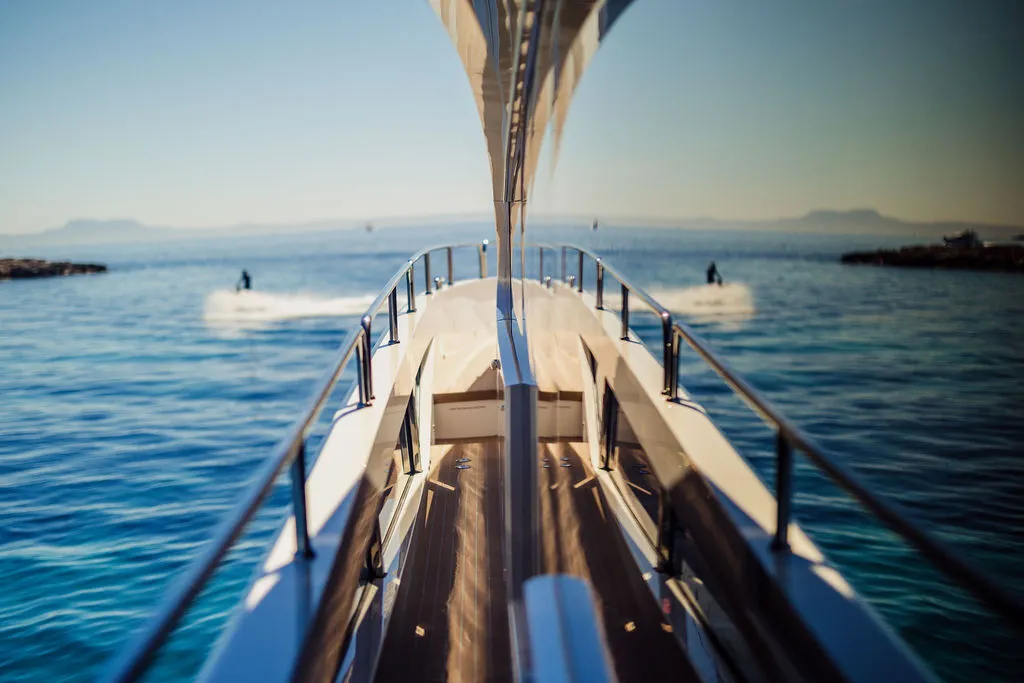 Bug-Detail einer modernen Motoryacht vor Mallorca — polierte Beschläge und Teakdeck im Sonnenlicht, charakteristische Linienführung einer Luxus-Motorjacht