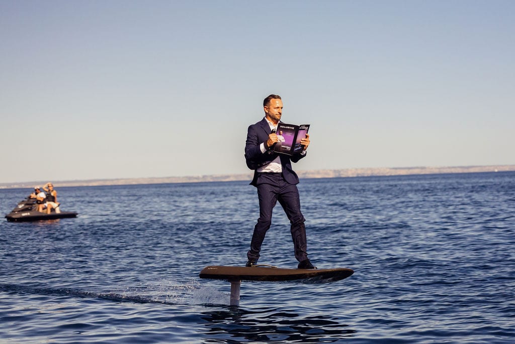 Julian Hoeke auf einem E-Foil vor Mallorca im Anzug — der unverkennbare Stil von Hoeke Yachting beim Yachtkauf